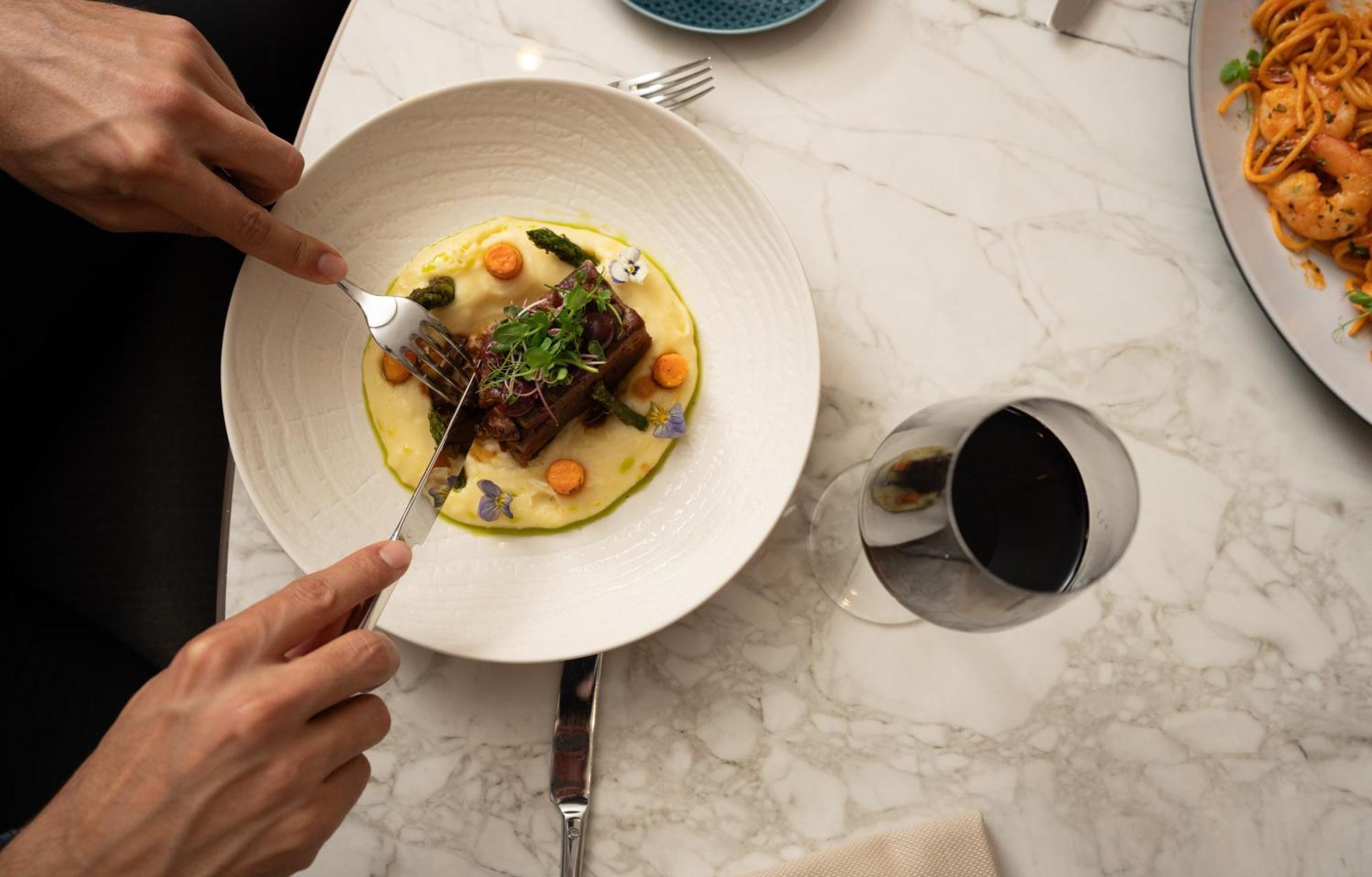 Address Istanbul Hotel Luaran gambar A person using a fork to cut into a meal
